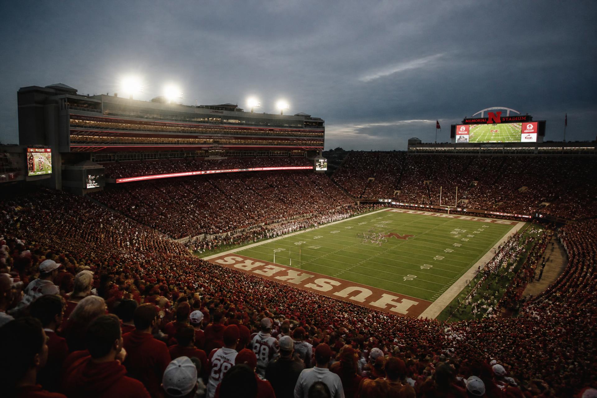 College football crowd filling a stadium bowl under the lights